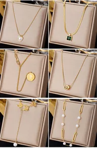 Detailed grid of six gold necklaces featuring pearls, emerald pendants, and coins