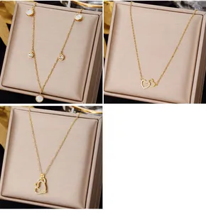 Macro shot of gold stainless steel necklaces featuring emerald pendants and heart charms