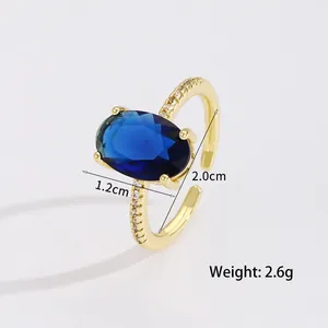 Vintage gold open ring featuring a deep blue oval gemstone and white zircon accents