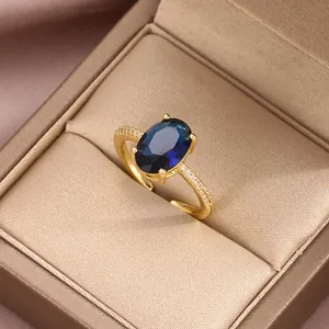 Macro shot of gold-plated adjustable ring with blue oval gemstone and cubic zirconia