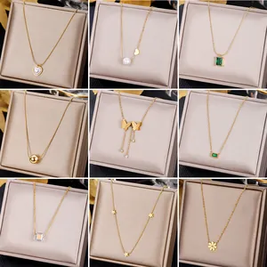 Collection of nine gold stainless steel necklaces with emerald and heart pendants