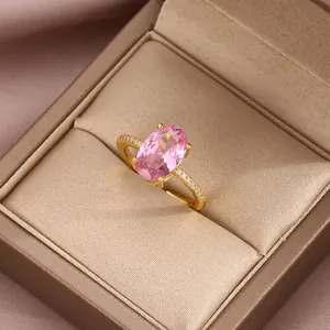 Close-up of luxury gold ring with oval pink zircon and sparkling pave diamonds
