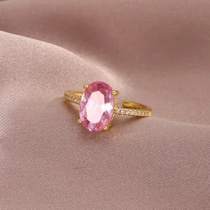 Detailed close-up of a luxury gold ring featuring an oval pink zircon and paved diamonds