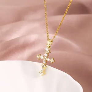 Collar de cruz dorada brillante con cristales de circonita sobre un elegante fondo satinado