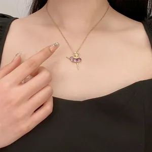 Detail einer goldenen Ballerina-Kette mit lila und rosa Zirkonia an einem Model getragen