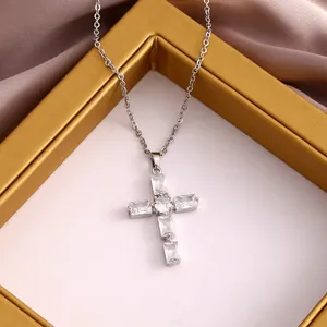 Primer plano del colgante de cruz de plata con circonitas sobre una cadena fina