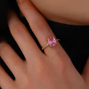 Macro shot of an elegant gold ring with a pink oval zircon and pave diamond band