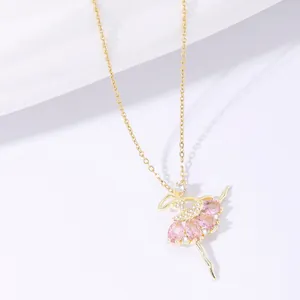 Makro-Detail von goldenem Ballett-Anhänger mit rosa Steinen und glitzernden Kristallen