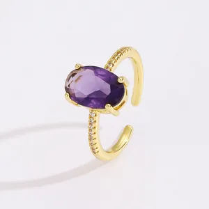 Close-up of golden adjustable ring with large oval purple stone and pavé zircon accents