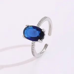 Macro detail of silver adjustable ring with oval blue gemstone and micro-pave zircons