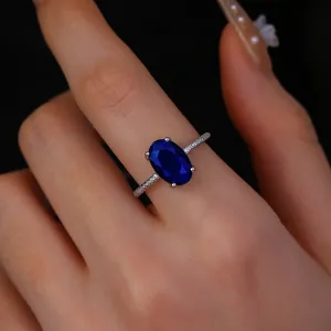Close-up of a luxury vintage silver ring with oval blue sapphire zircon on a model's hand