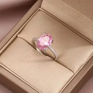 Macro detail of luxury pink oval gemstone ring with side-set zircons on silver band