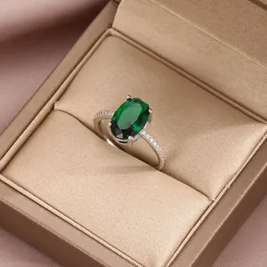 Close-up of vintage silver ring with oval green gemstone and pavé diamonds in a jewelry box
