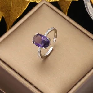 Close-up of luxury adjustable silver ring with oval purple gemstone and cubic zirconia
