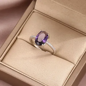 Macro detail of luxury silver ring with oval purple gemstone in golden jewelry box