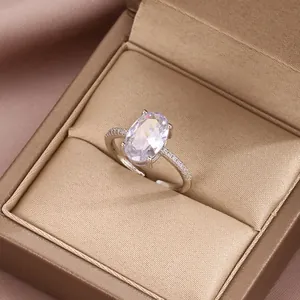 Detailed close-up of an oval-cut zircon ring with pavé accents in a gold velvet jewelry box