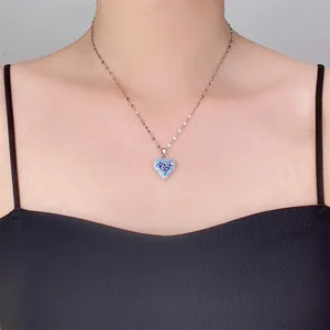 Primer plano de collar con colgante de corazón y piedras azules en una modelo