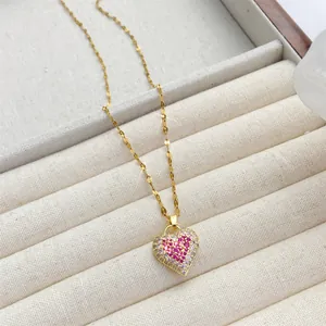 Elegante collar de corazón en titanio dorado con circonitas rosas sobre terciopelo