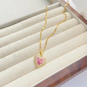 Primer plano del colgante de corazón dorado con circonitas cúbicas rosa y blanco