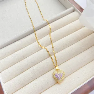 Detalle de un colgante de corazón brillante con circonitas en collar dorado