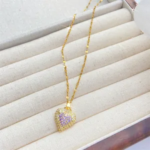 Detalle del collar de corazón con circonita púrpura incrustada en caja de joyería fina
