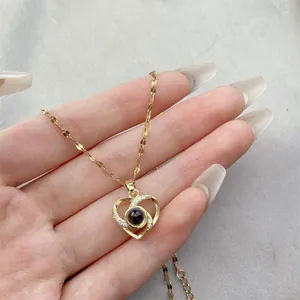 Detailed view of gold heart necklace with micro-pave zircon and central projection stone