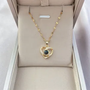 Macro view of gold heart projection necklace with zircon inlay on jewelry box