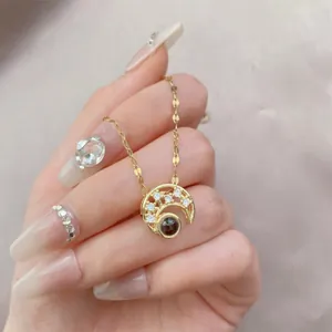 Golden crescent moon necklace with projection stone and micro-set cubic zirconia crystals