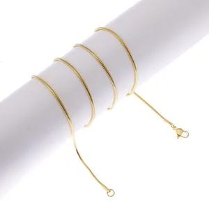 Close-up of a slim golden snake chain necklace with lobster clasp on a white stand