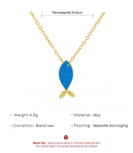 Détail du collier pendentif poisson tropical doré avec émail bleu et pierres de zircon