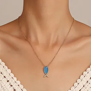 Collier bohème doré avec pendentif poisson bleu et cristaux porté par un mannequin