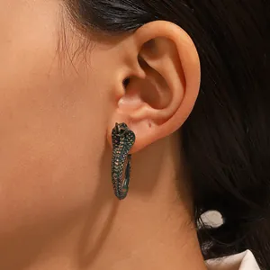 Close-up of vintage cobra earrings with detailed scales on model's earlobe