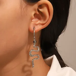 Detailed close-up of punk style silver snake earrings featuring textured scale finish