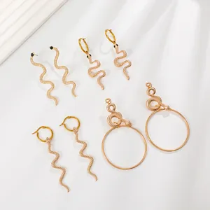 Set of four unique gold snake drop earrings with detailed scale texture and black bead eyes