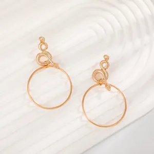 Detailed close-up of gold snake earrings featuring textured reptile design and large hoop