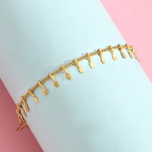 Close-up of golden stainless steel tassel bracelet on blue cylindrical display