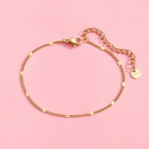 Macro shot of gold stainless steel curb chain bracelet with starburst charms and tag