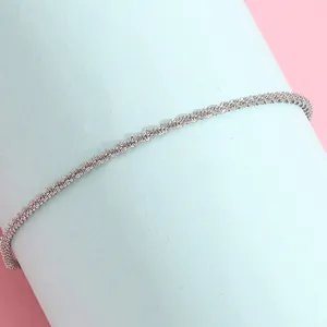 Detailed macro of a silver twisted chain bracelet showcasing fine metal texture and gloss