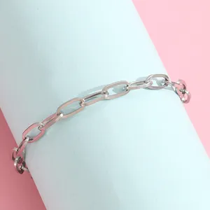 Detailed shot of silver stainless steel paperclip chain bracelet on a soft pastel display