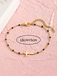 Detailansicht der goldfarbenen Edelstahl-Fußkette mit Kreuz, schwarzen Perlen und Maßangabe