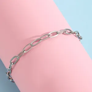 Détail d'une chaîne à maillons argentée en acier inoxydable sur un support d'exposition rose