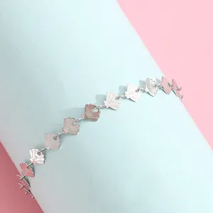 Detail view of silver shell charm bracelet with fan-shaped links on blue stand
