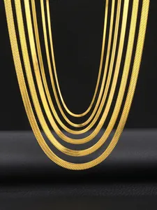 Detailed comparison of various widths of golden herringbone chains on a black leather stand