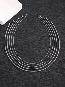 Detail of four silver snake bone necklaces in different thicknesses on black leather