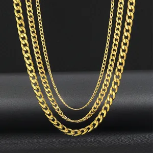 Τρία χρυσά κολιέ Cuban link σε διαφορετικά πλάτη σε βάση παρουσίασης κοσμημάτων