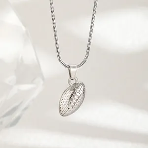 Dettaglio di un ciondolo football americano argento con texture e catena a serpente