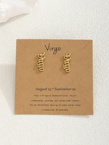 Boucles d'oreilles signe astrologique Vierge dorées sur carte de présentation kraft