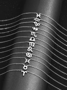Détail de colliers constellation argentés disposés sur un support noir au thème étoilé