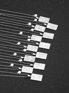 Flache Darstellung von zwölf silbernen Sternzeichen-Halsketten mit Gravur auf Schwarz
