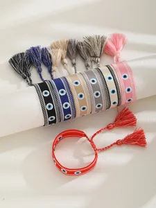 Detail of woven evil eye bracelets with vibrant tassels in bohemian style and various colors